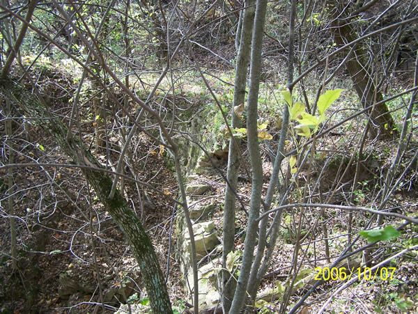 The same retaining wall as seen on the historic photo today, now crumbling.